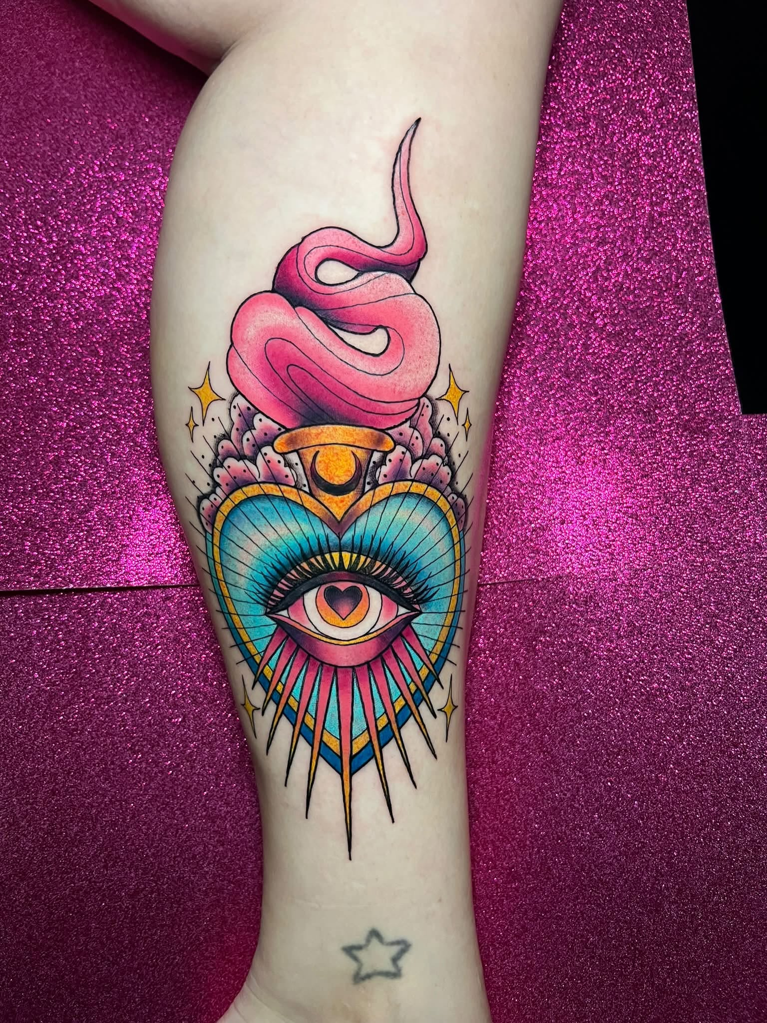 Colorful eye and snake tattoo with celestial details