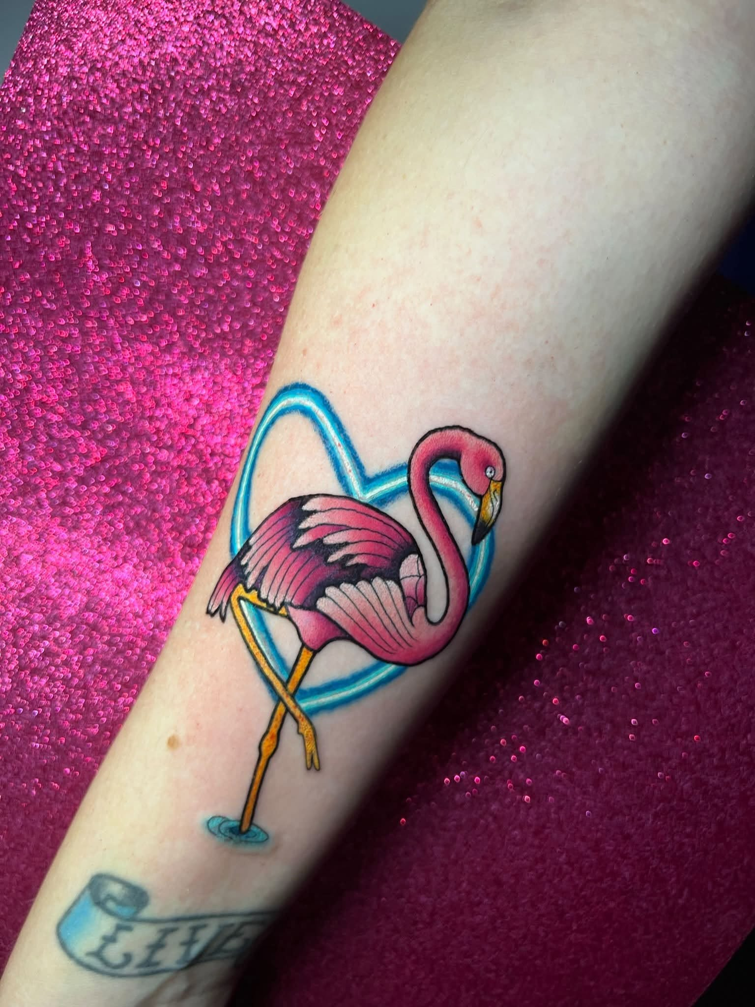 Pink flamingo tattoo inside a blue heart
