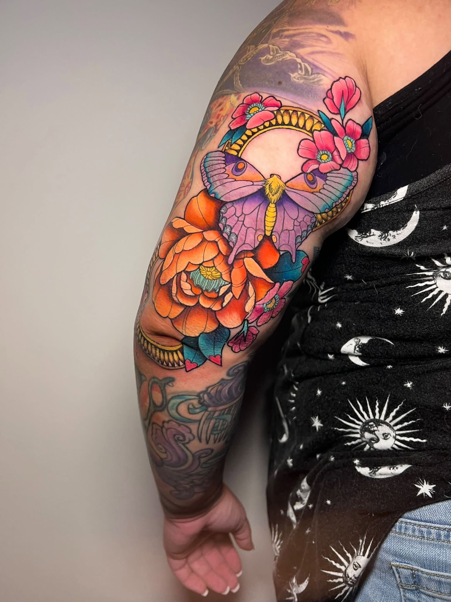 Colorful moth and floral tattoo